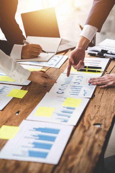 Teamwork with price chart analyzes business people on the table Teamwork with price chart analyzes business people on the table