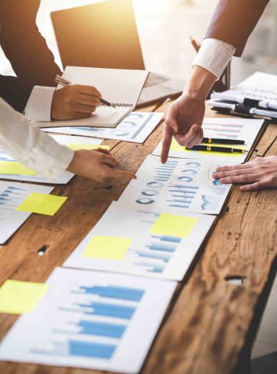 Teamwork with price chart analyzes business people on the table Teamwork with price chart analyzes business people on the table